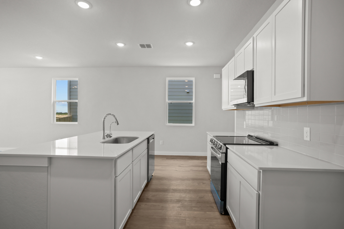 A kitchen with white cabinets.