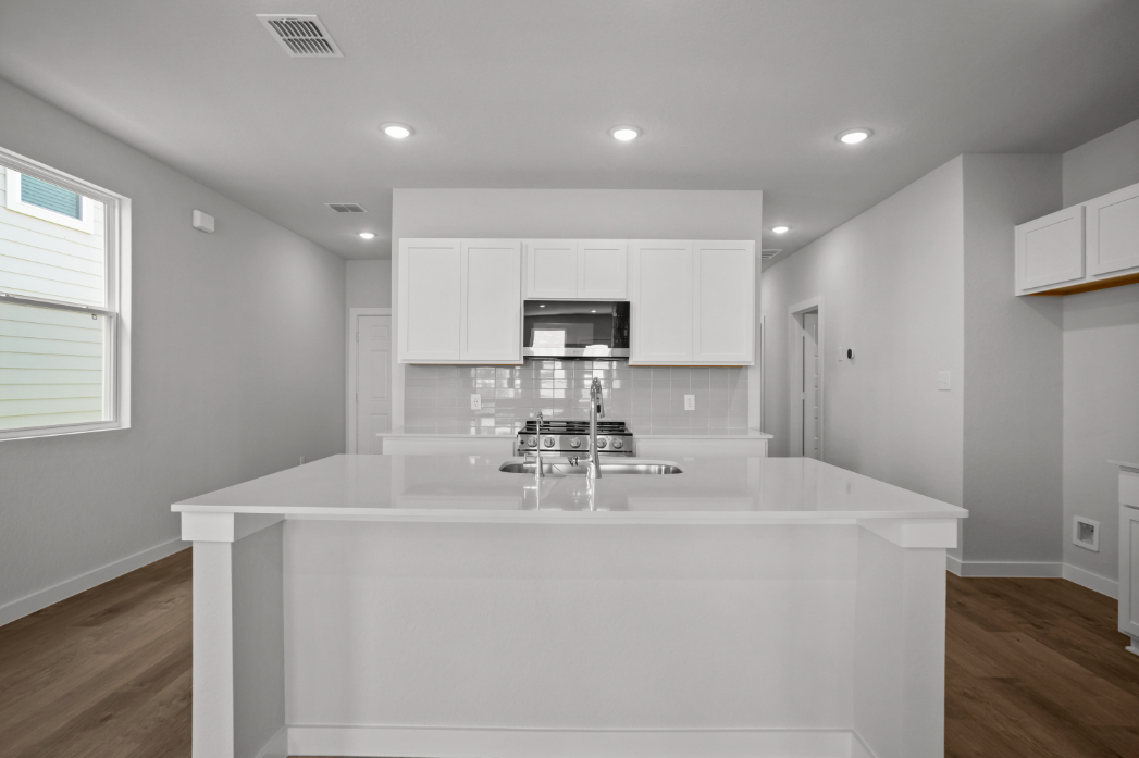 A kitchen with white cabinets.