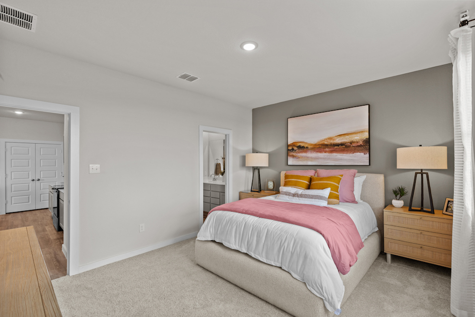 A bedroom with a bed and lamps.