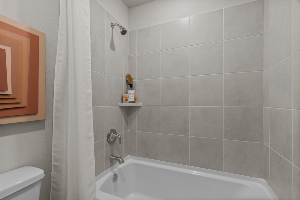 A bathroom with a bathtub and toilet.