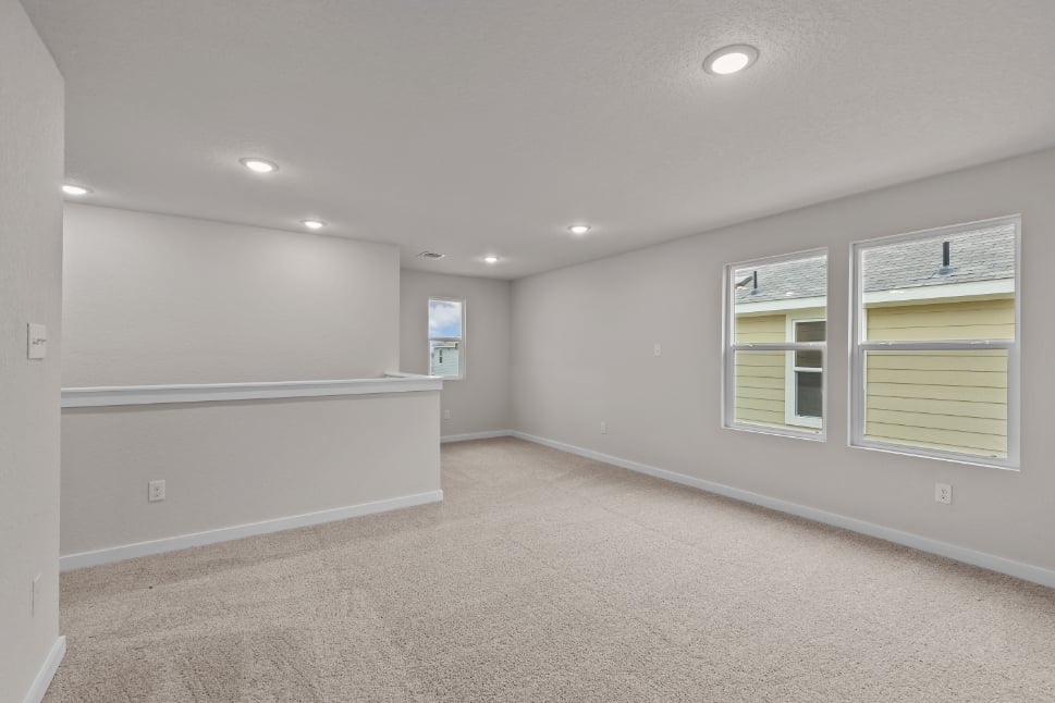 A room with a white wall and windows.