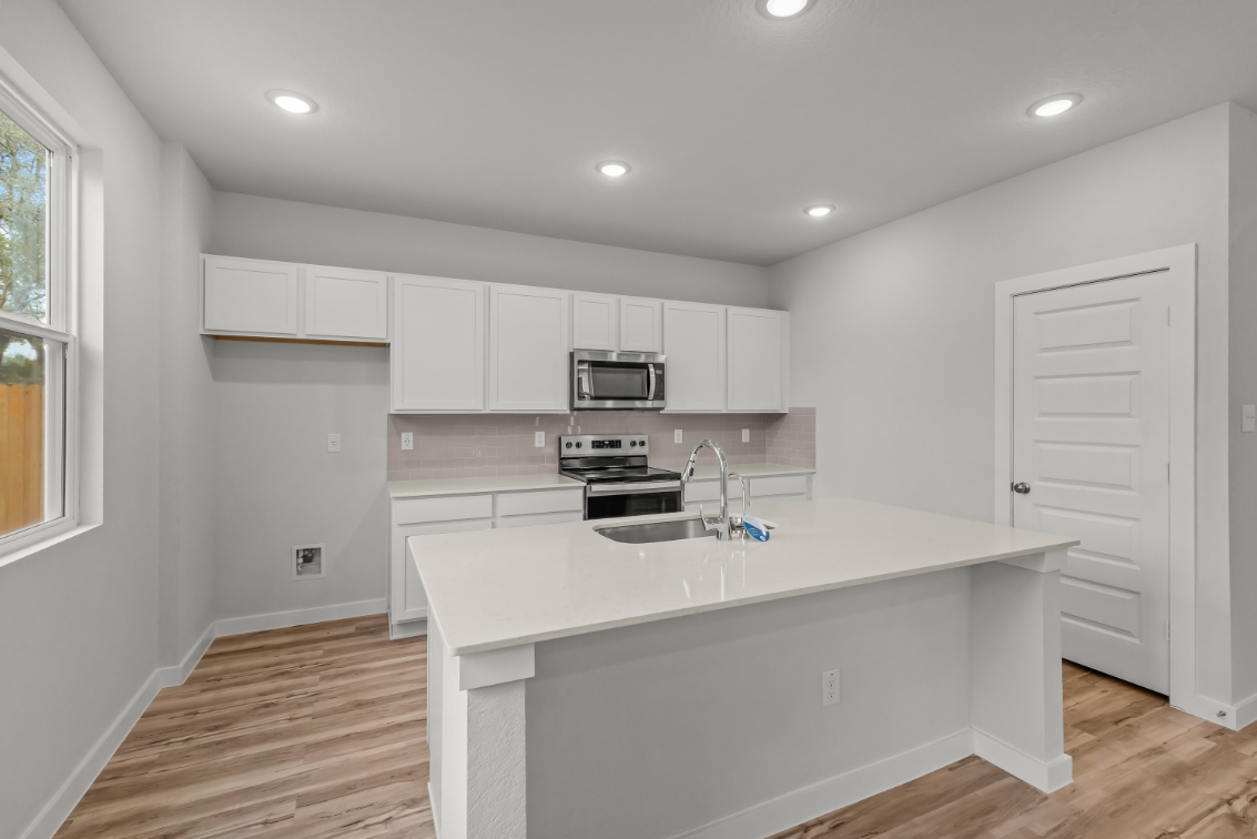 A kitchen with white cabinets.