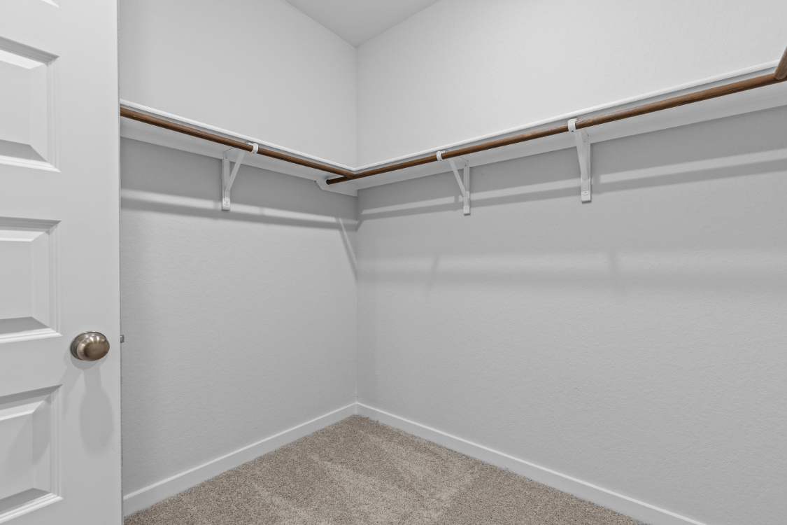 A white wall with a metal bar.