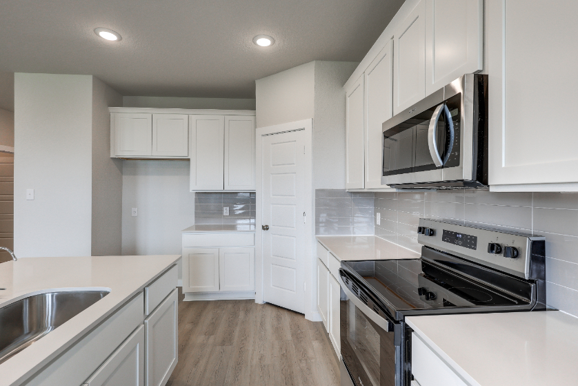 A kitchen with white cabinets.