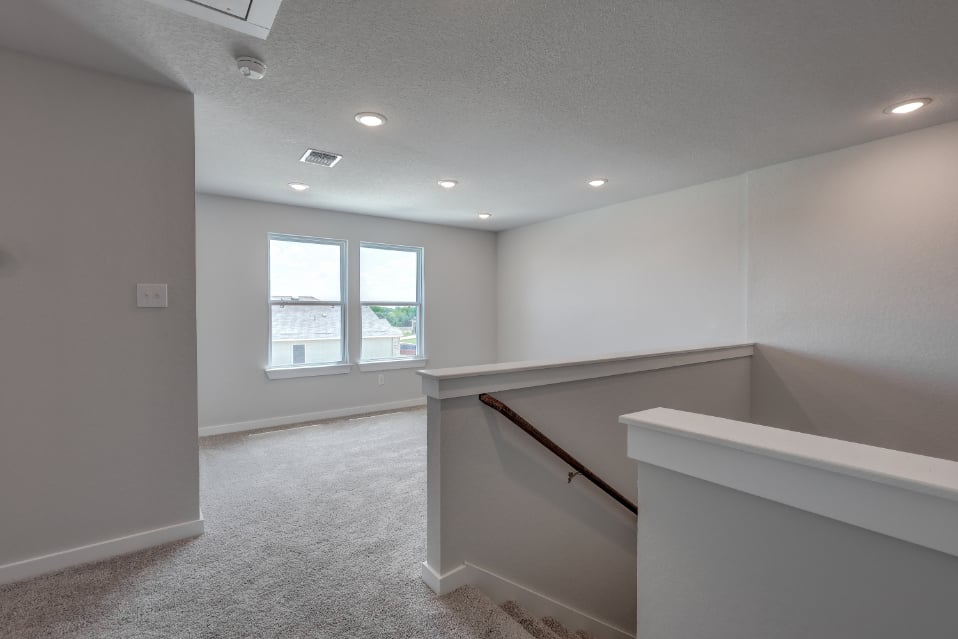A room with a window and a staircase.