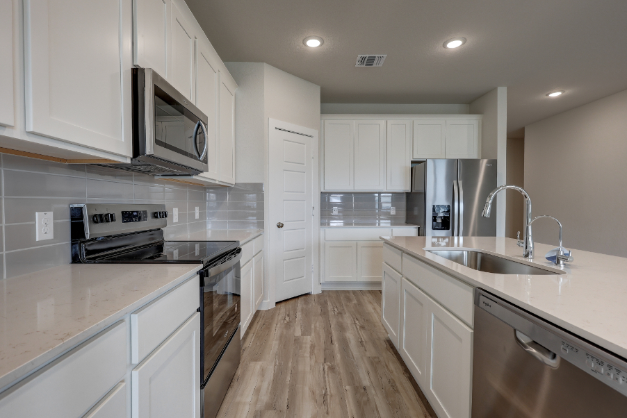 A kitchen with white cabinets.