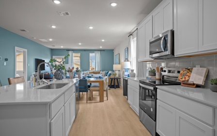 A kitchen with white cabinets.