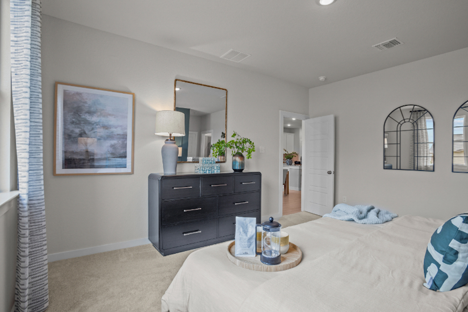 A bedroom with a bed and dresser.