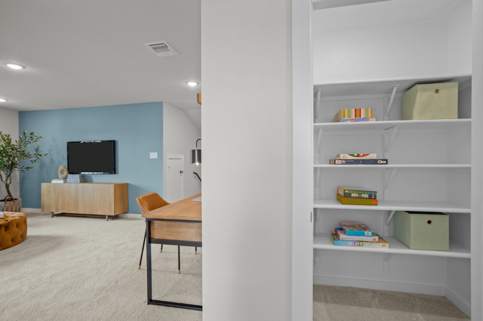 A room with a desk and shelves.