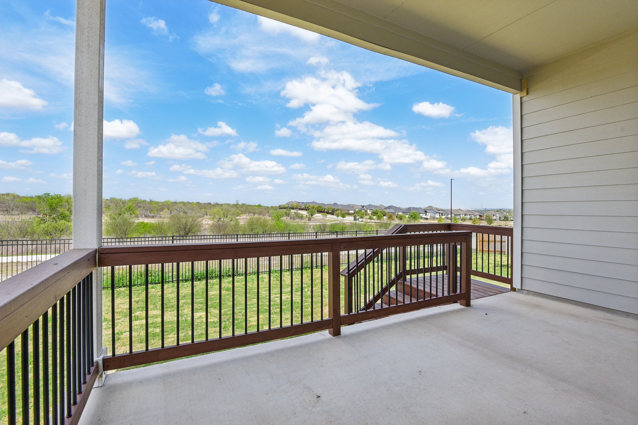 A deck with a railing and trees in the background.