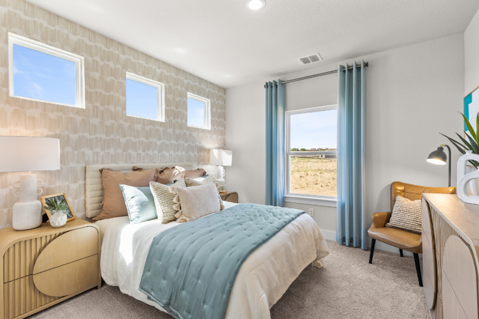 A bedroom with a bed and a chair.