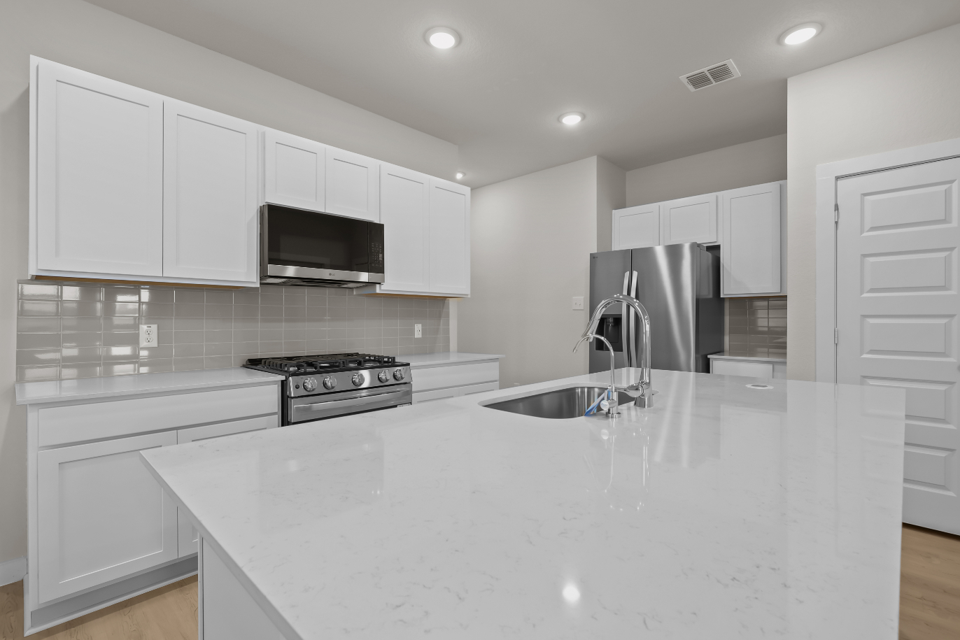 A kitchen with white cabinets.