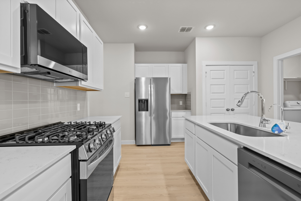 A kitchen with white cabinets.