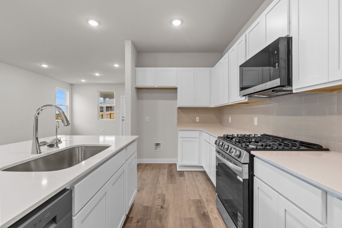 A kitchen with white cabinets.