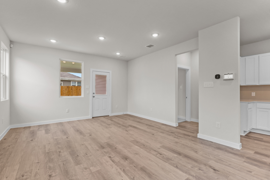 A room with white walls and wood floors.