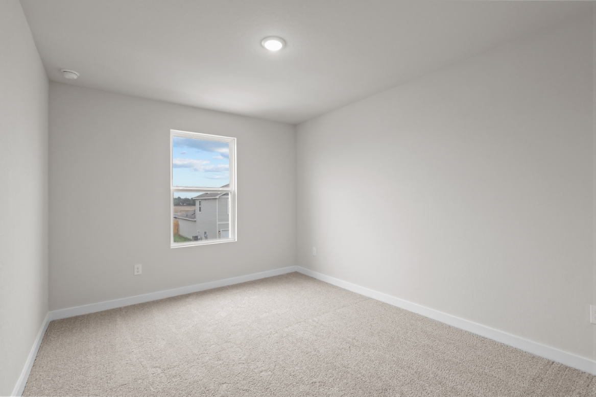 A room with a window and a painting on the wall.