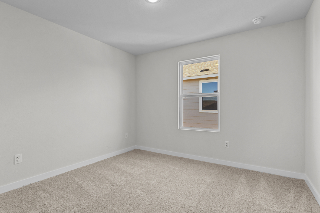 A room with a window and carpet.