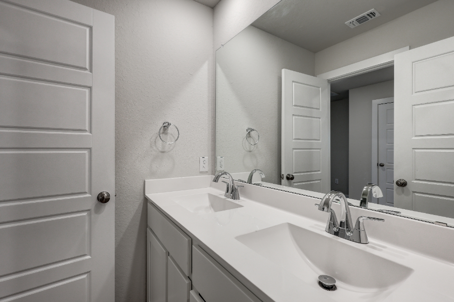 A bathroom with a large mirror.