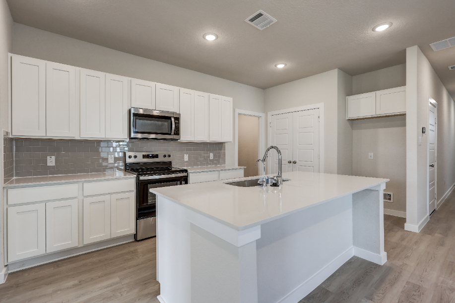 A kitchen with white cabinets.