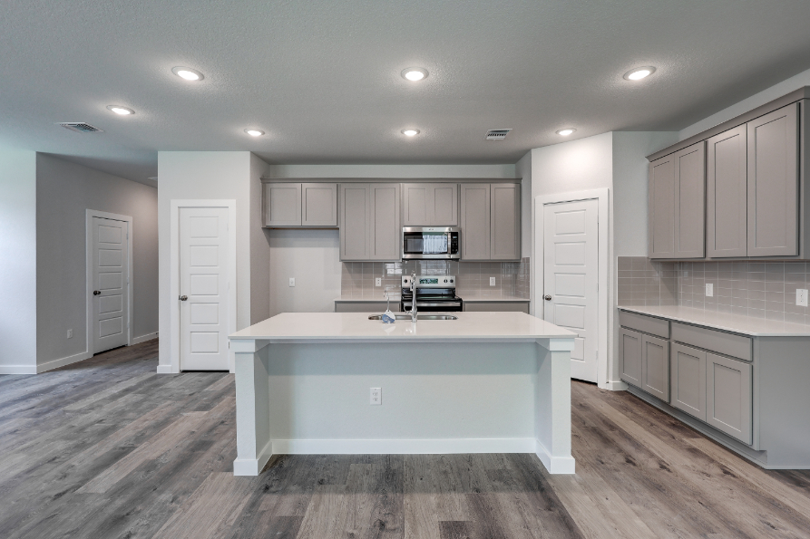 A kitchen with white cabinets.