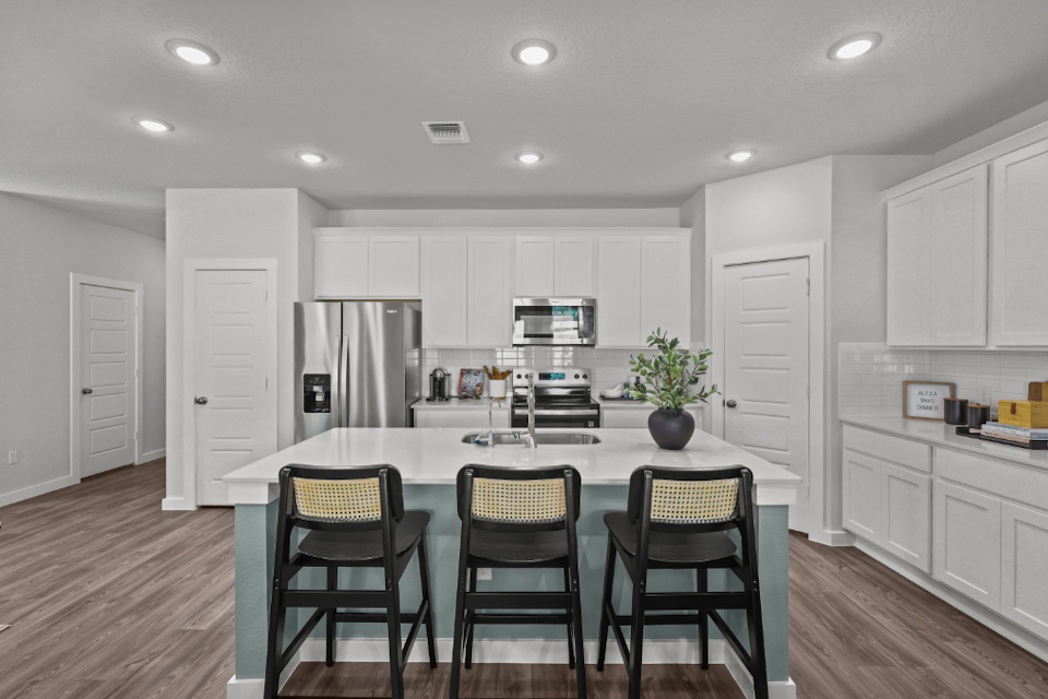A kitchen with white cabinets.