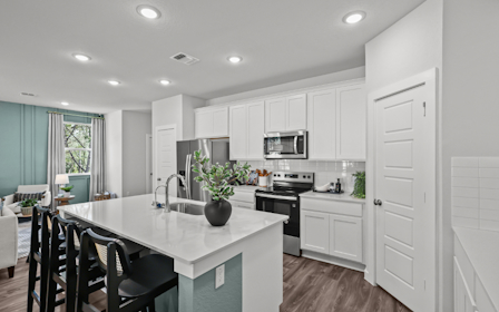 A kitchen with white cabinets.