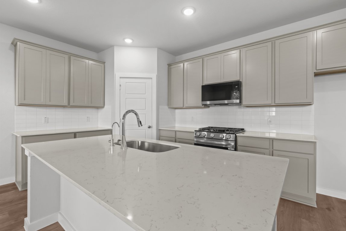 A kitchen with white cabinets.