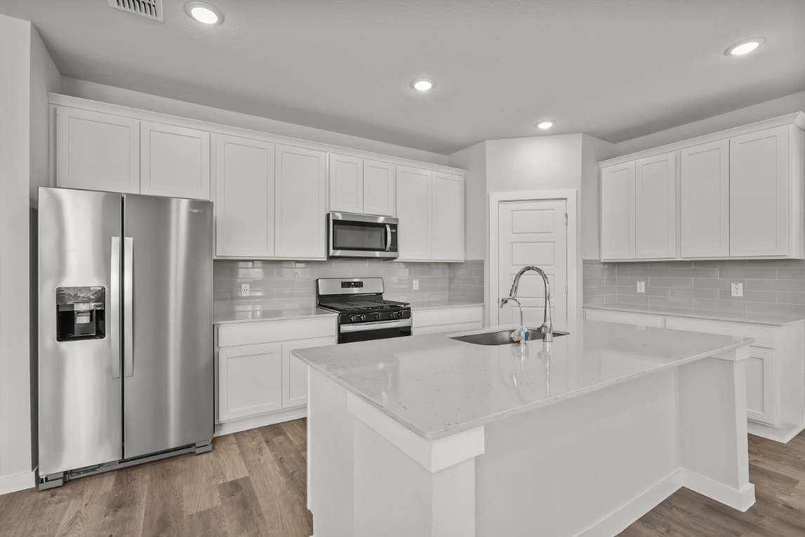 A kitchen with white cabinets.