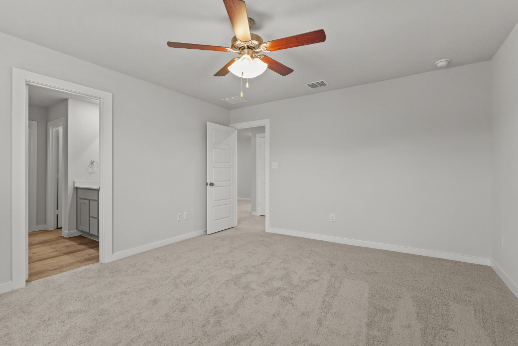 A room with a ceiling fan and white walls.