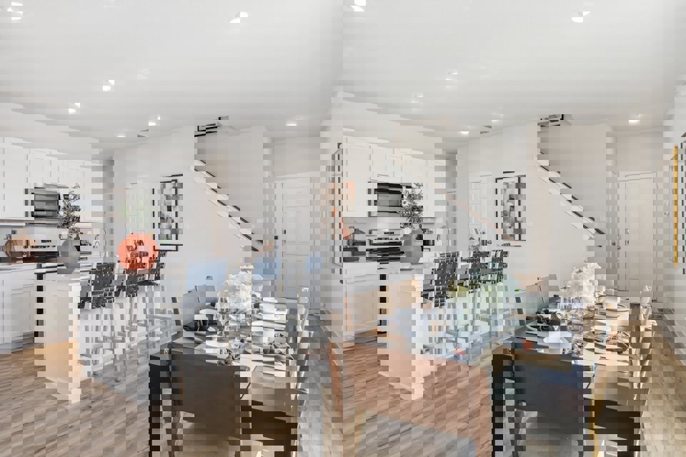 A kitchen with a dining table and chairs.