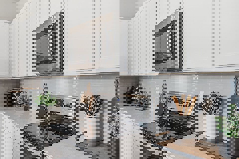 A kitchen with white cabinets.