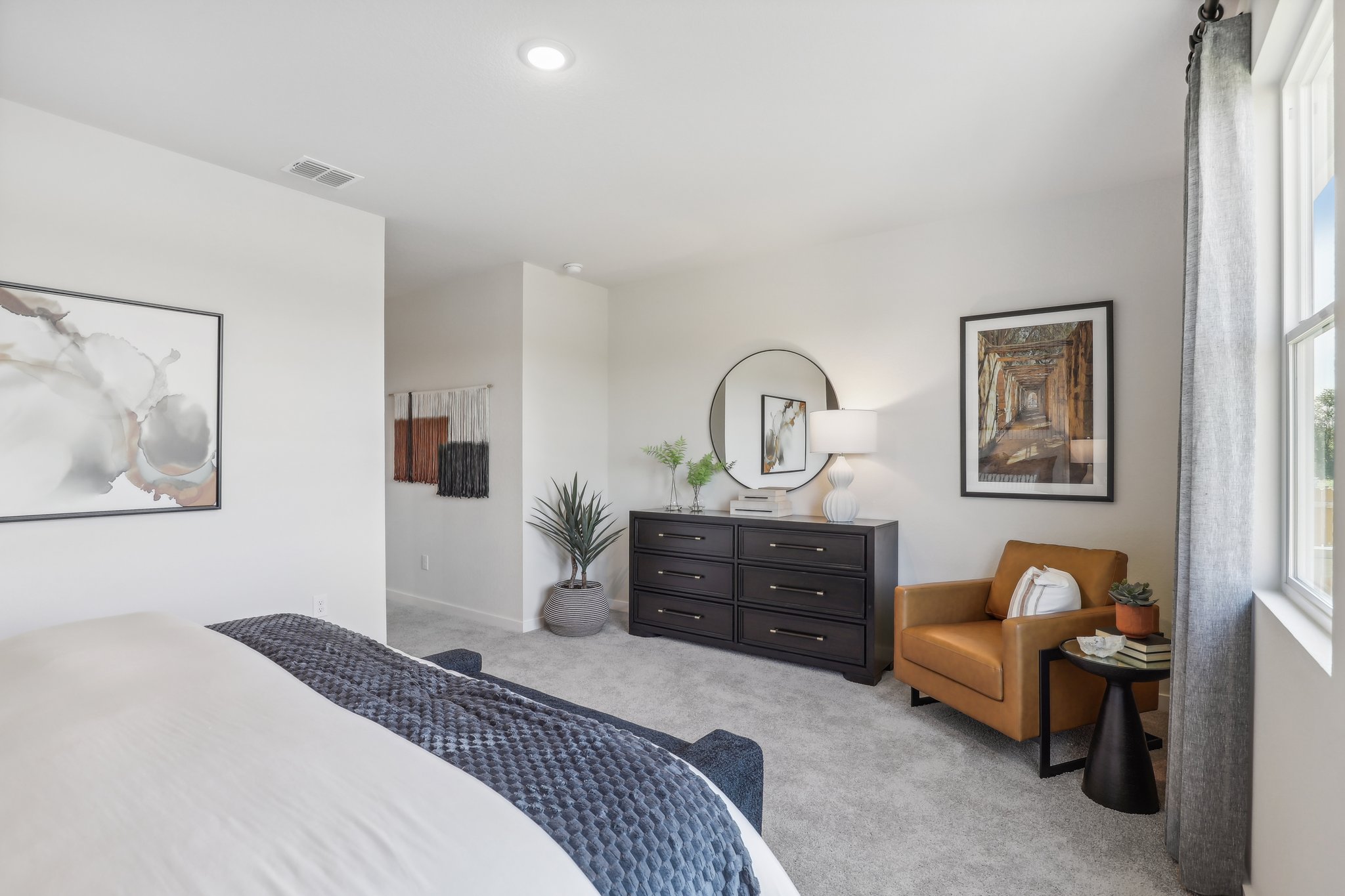 A bedroom with a bed and a chair.