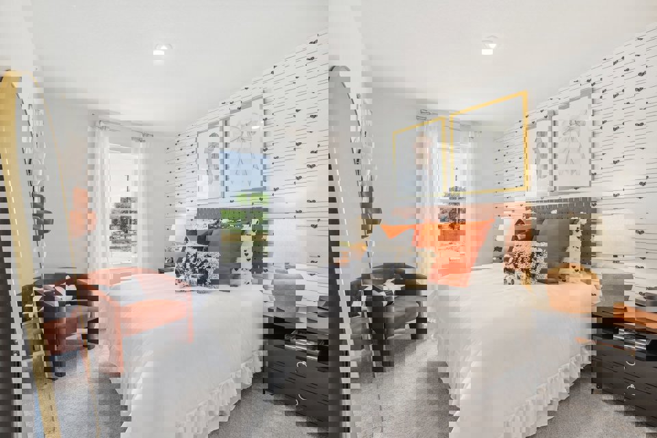 A bedroom with a bed and a chair.