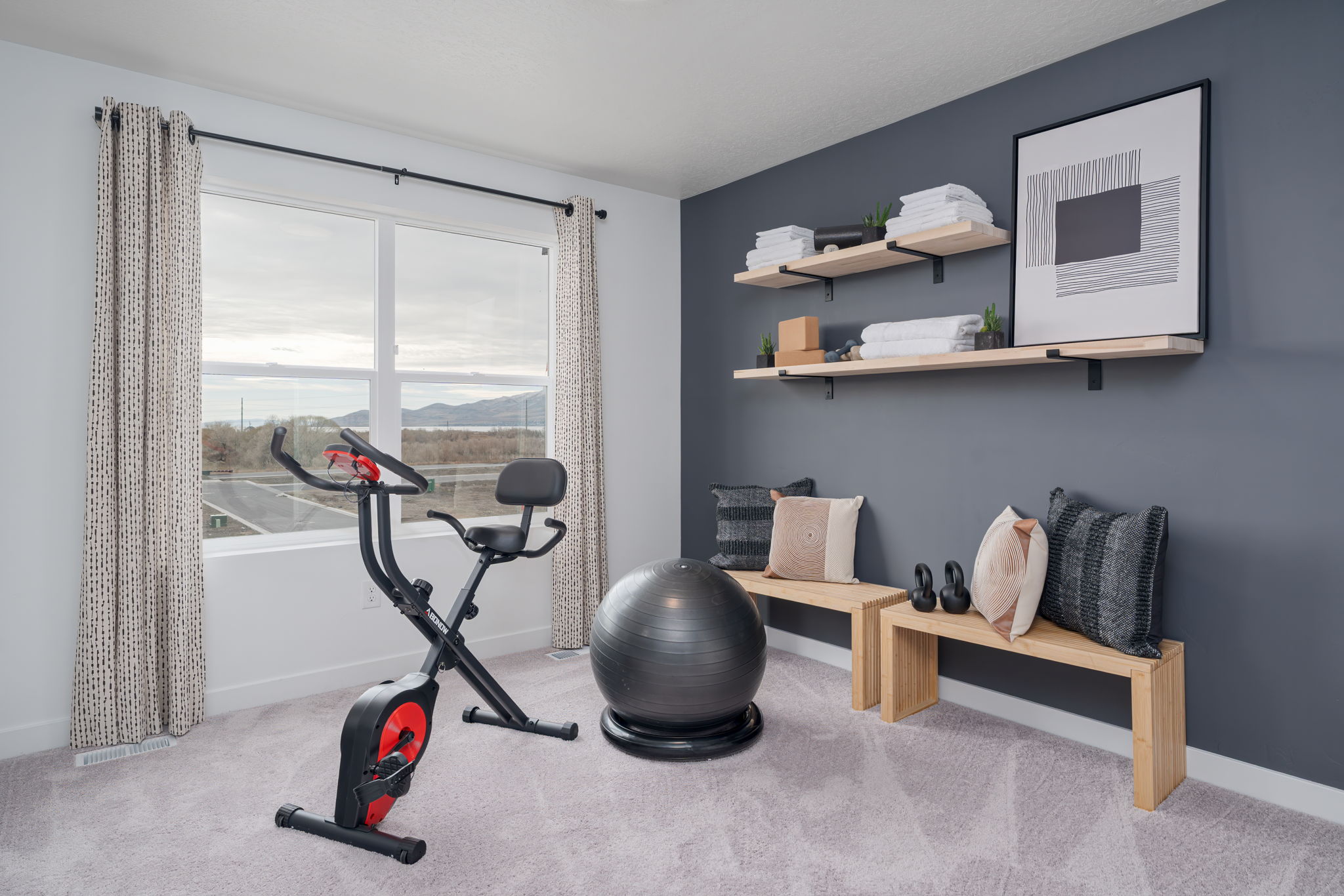 A room with a desk and a chair and a window with a view of a city.
