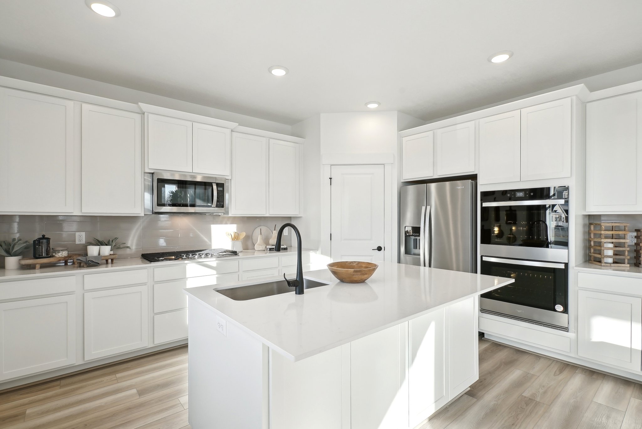 A kitchen with white cabinets.
