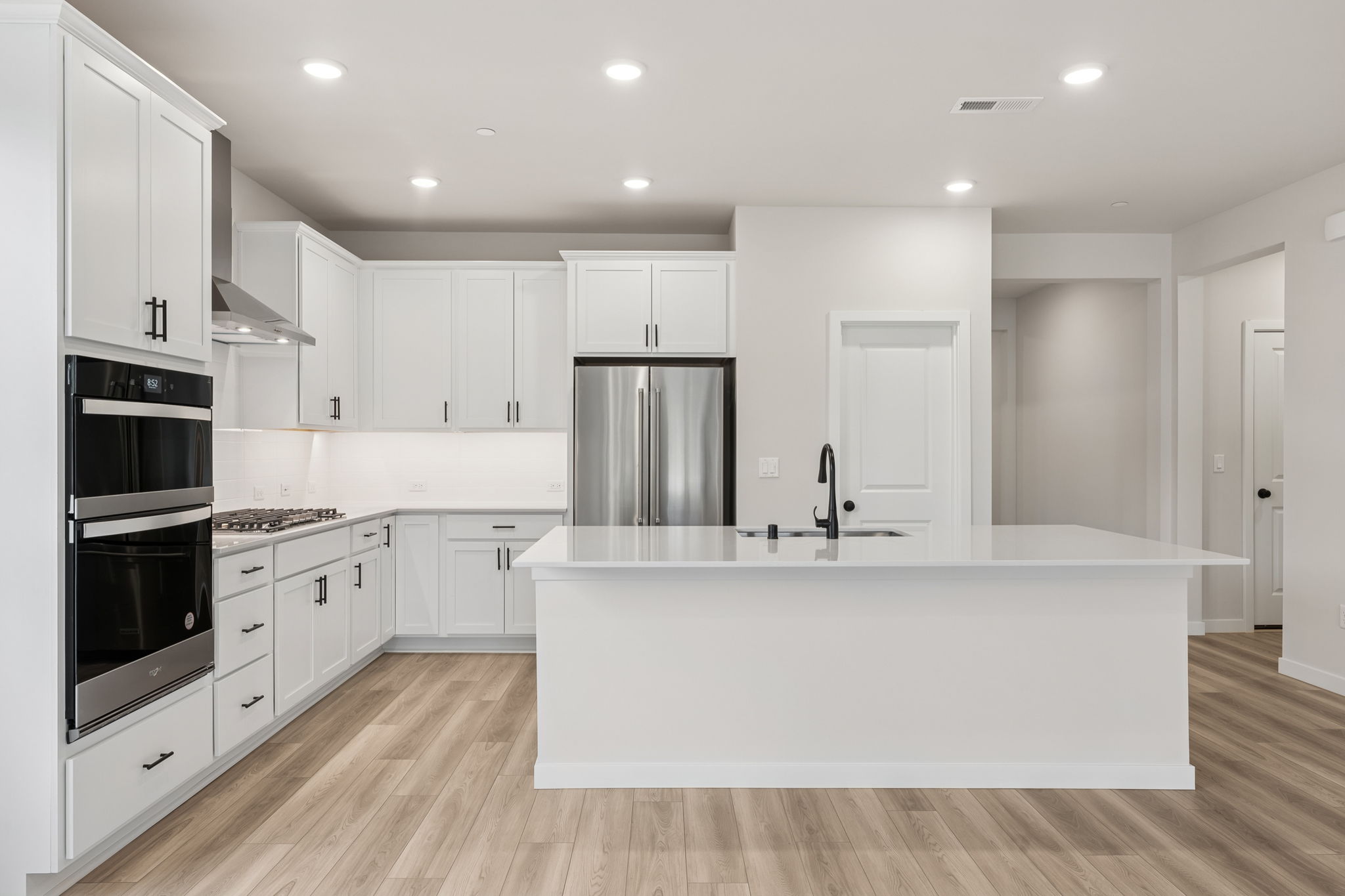 A kitchen with white cabinets.