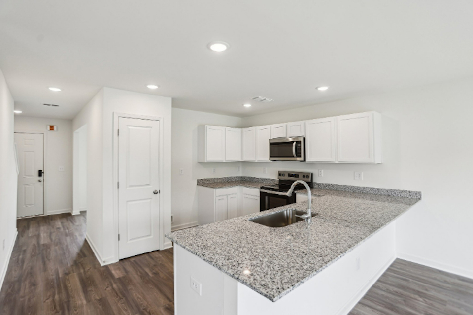 A kitchen with white cabinets.