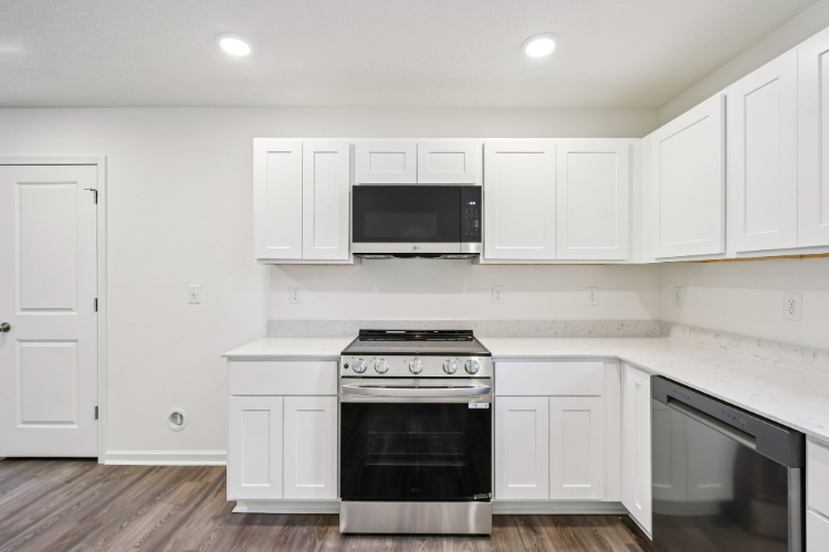A kitchen with white cabinets.