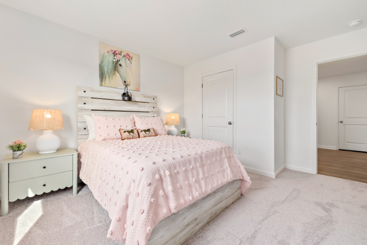 A bedroom with a bed and lamps.