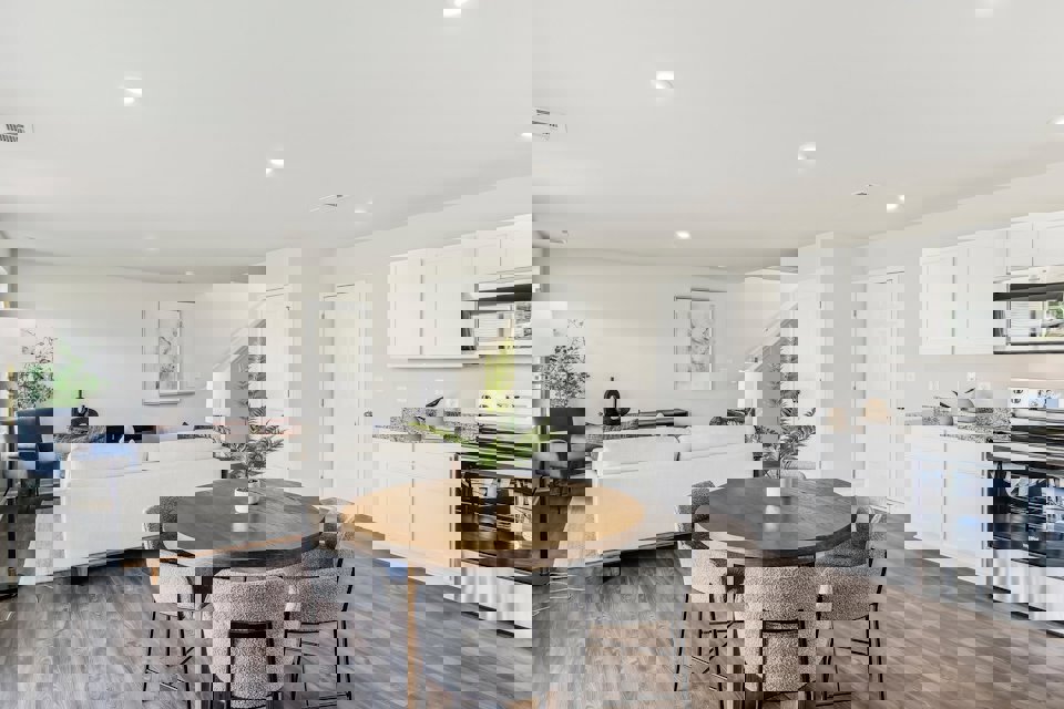 A kitchen with a table and chairs.