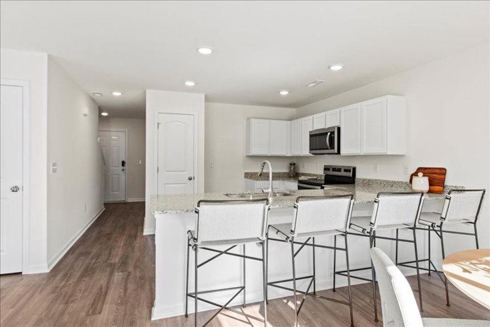 A kitchen with white cabinets.