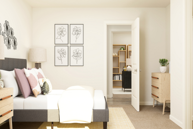 A living room with a white couch and a white wall with art on it.