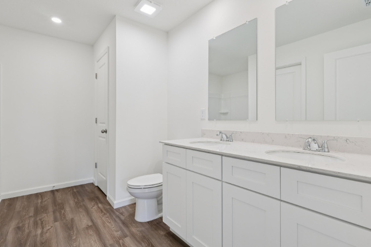 A bathroom with white cabinets.