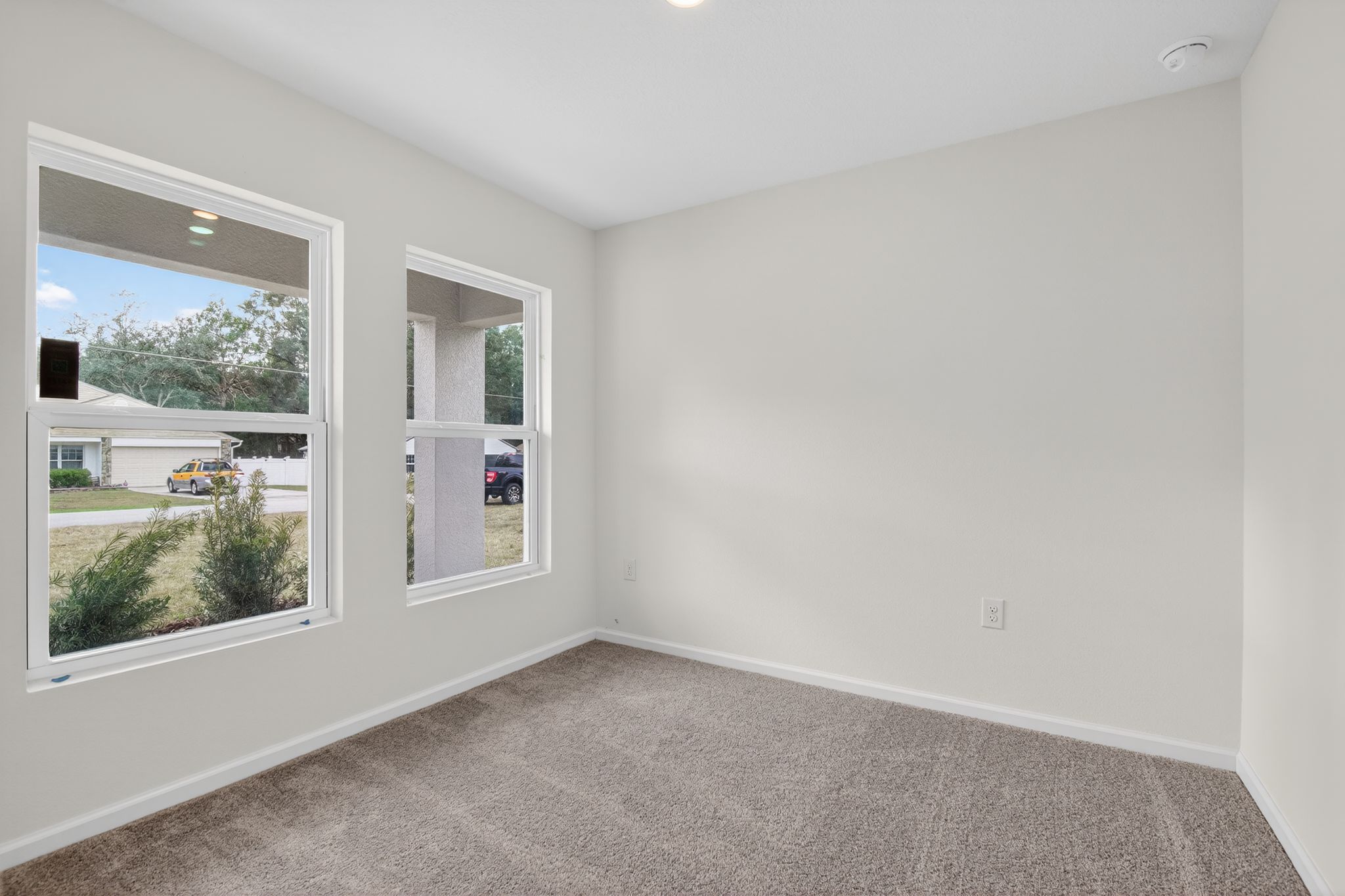 A room with windows and a carpet.