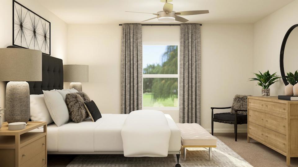 A living room with a white couch and a black chair.