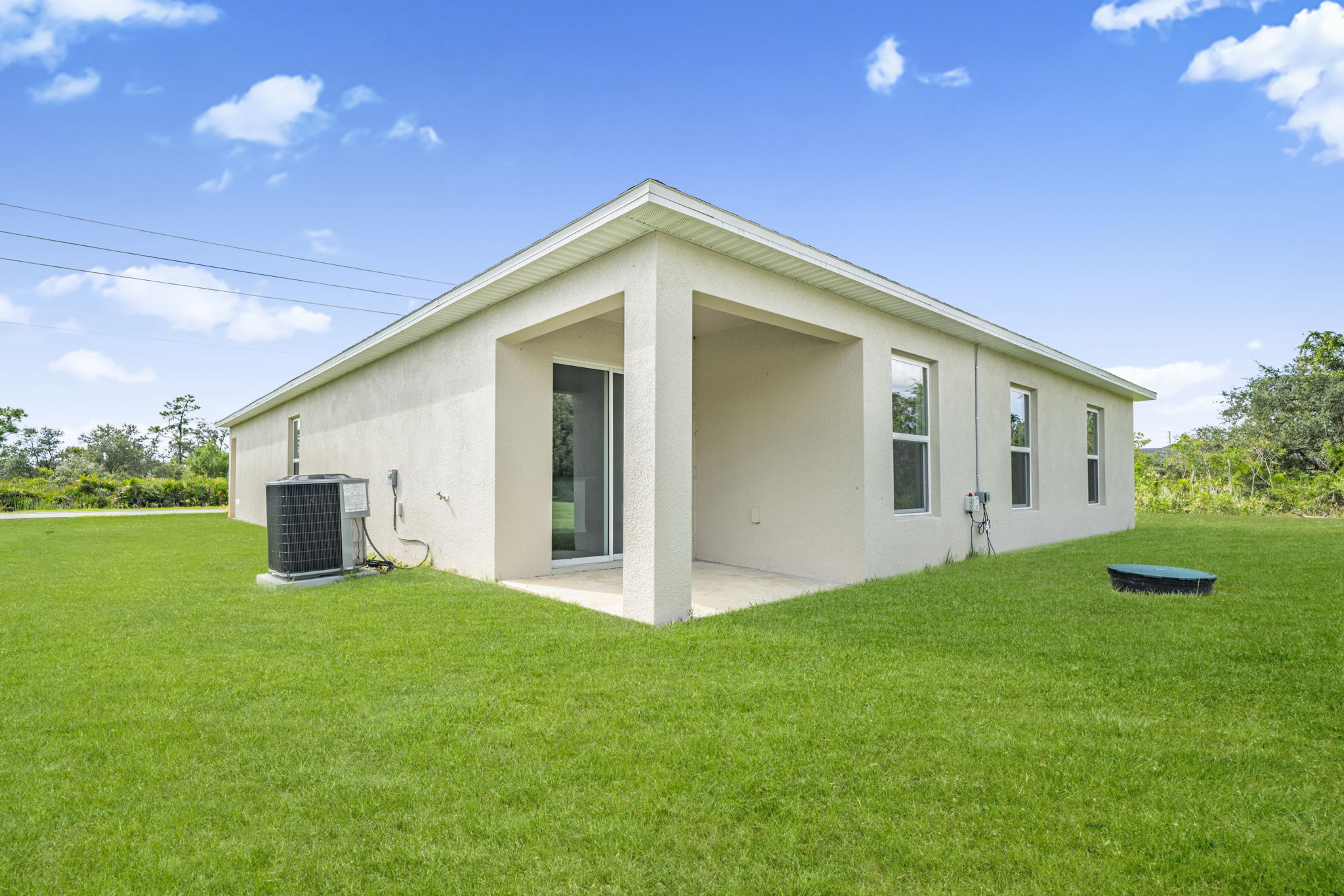 A white house with a green lawn.