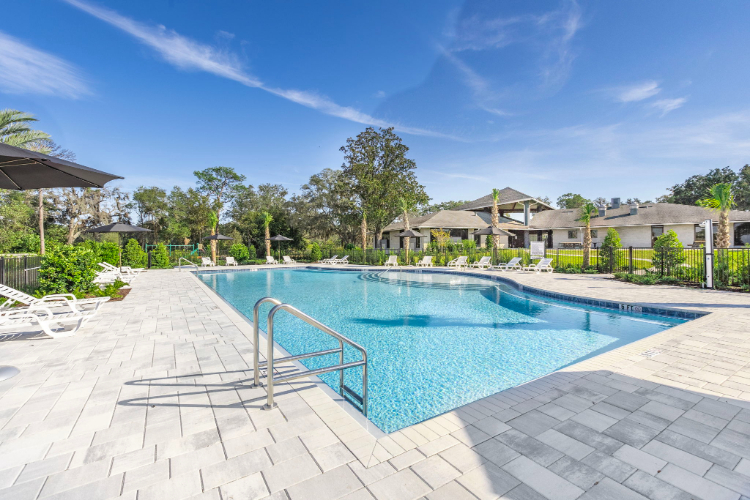 A swimming pool with a fence around it and a house in the background.