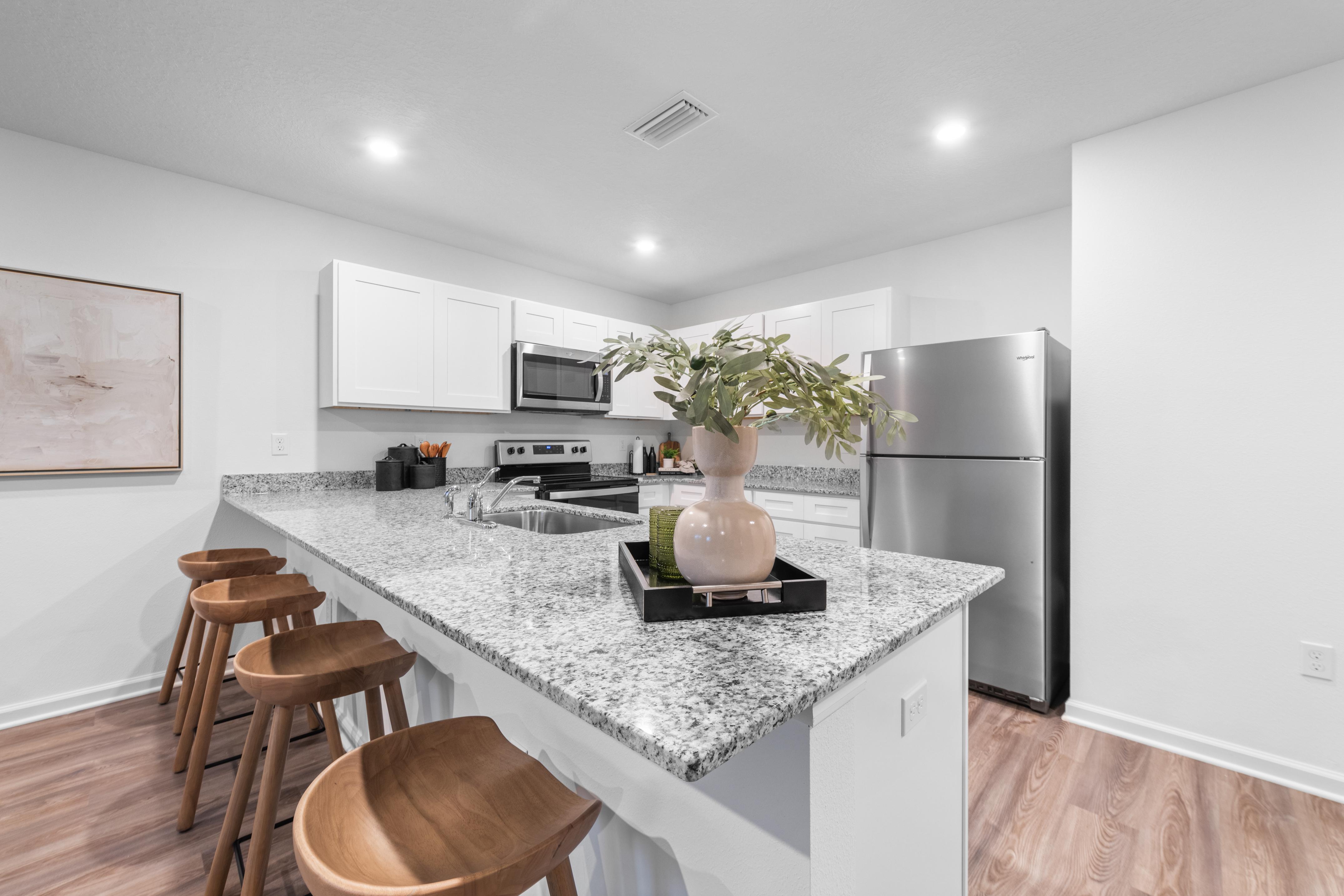 Kitchen with granite countertops and white cabinets. 
