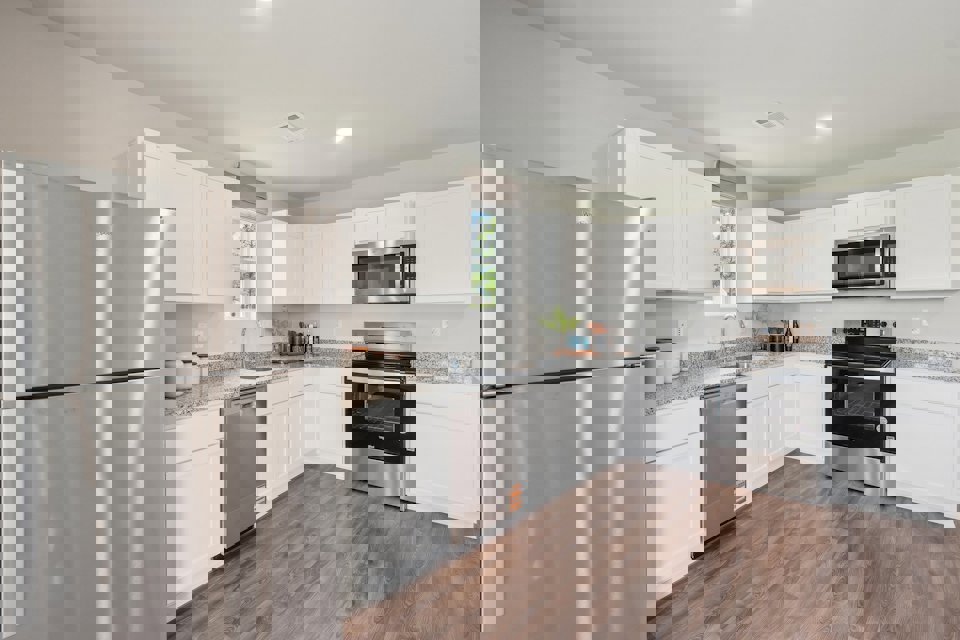 A kitchen with white cabinets.