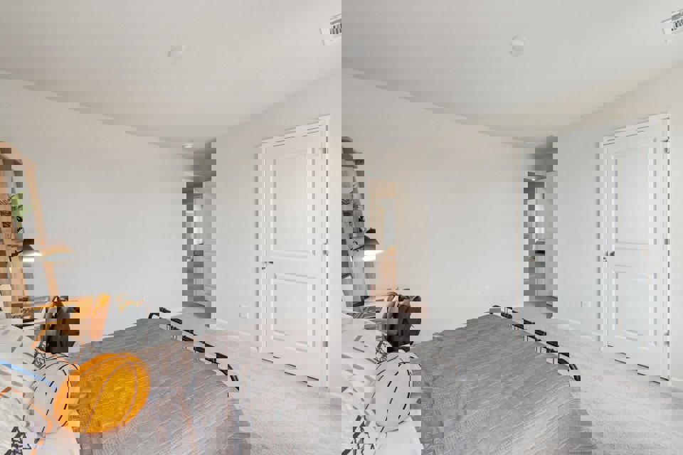 A bedroom with a bed and a lamp.